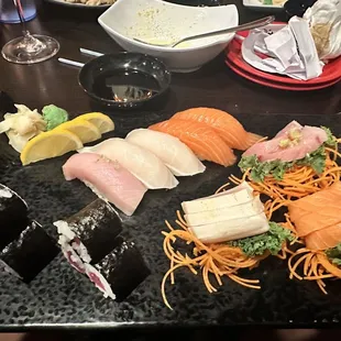 a variety of sushi on a black plate