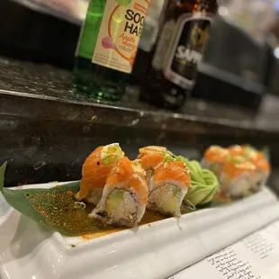a plate of sushi and a bottle of beer