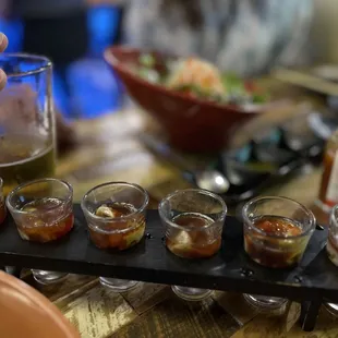 a tray of small glasses of condiments