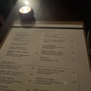 a menu and a candle on a table