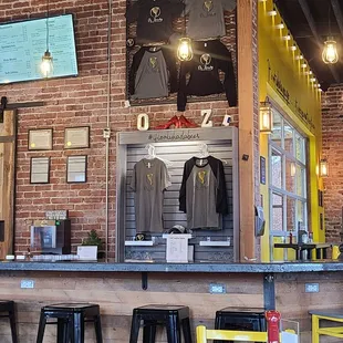 a bar with yellow chairs and a brick wall