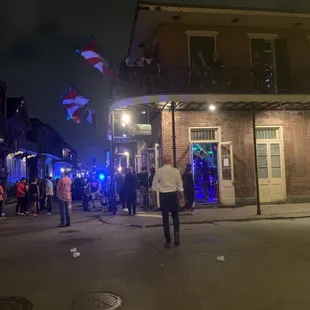 a group of people walking down a street at night