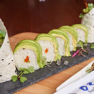 a sushi roll with avocado and carrots
