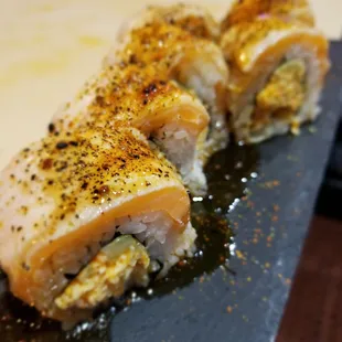 two pieces of sushi on a black plate