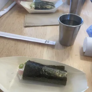 Negi hamachi temaki(fromt) vs blue crab sunomono temaki. Water cups.