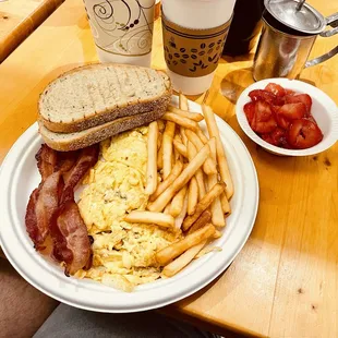 a breakfast of eggs, bacon and french fries