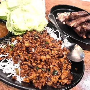  a plate of meat, rice, and lettuce