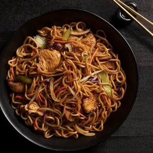  a bowl of noodles with chicken and vegetables