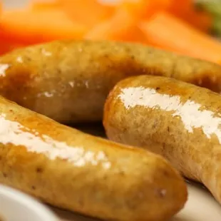 a plate of sausages, mashed potatoes and carrots
