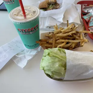 Grilled chicken burger in a lettuce wrap, fries and a vanilla shake.