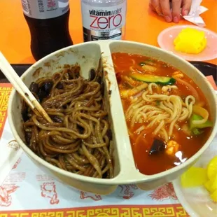 a bowl of noodles and a bottle of soda