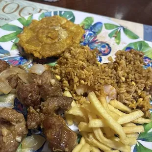 Tostones con ajo, carne frita, arroz y papas.