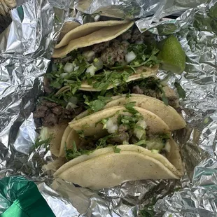 asada tacos! So delicious come with onion and cilantro. lime wedges, cucumber, and radish cuts on the side.