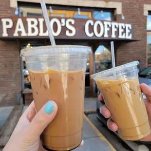 two cups of coffee in front of a coffee shop