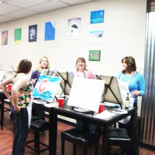 a group of women working on their paintings