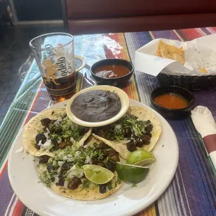 Al Pastor tacos black refried beans homemade tortilla chips. Home made hot sauce and homemade salsa.