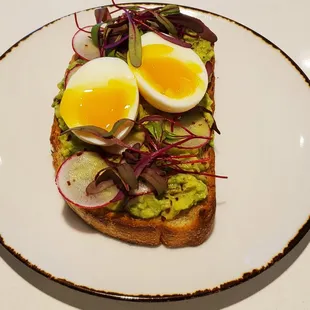 a toast with eggs, avocado and radishes