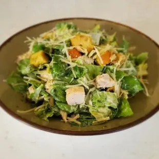 a salad with chicken, lettuce, and mangos