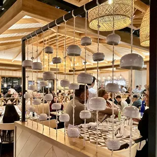 Medium sized restaurant with booths, tables, &amp; high tops, and cozy tropical cottage decor.