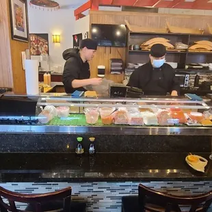 a sushi bar with people in the background