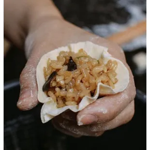 a person holding a dumpling of food
