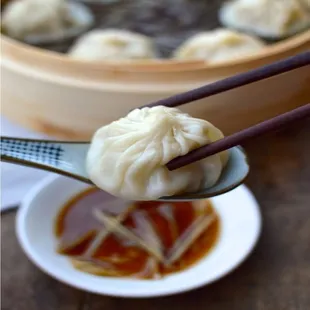 a dumpling being lifted by chopsticks