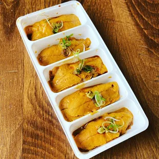 a tray of enchiladas on a wooden table