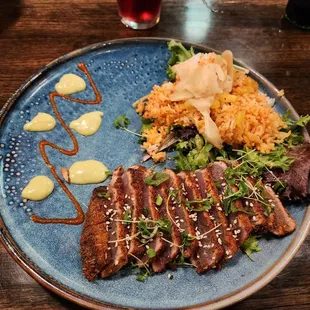 a plate of steak and rice