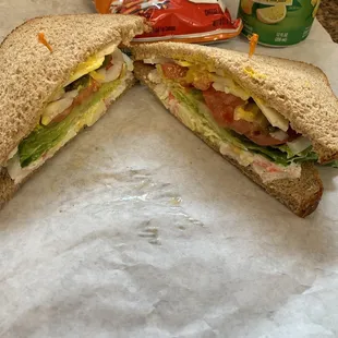 Crab Salad Sandwich on sliced wheat bread, with chips &amp; can of soda