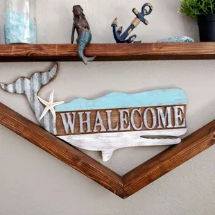 a whale welcome sign on a shelf