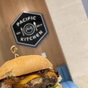 a hand holding a cheeseburger