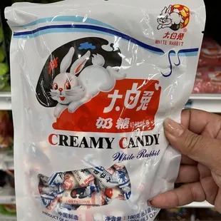 a hand holding a bag of candy