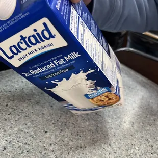 a person pouring milk into a carton