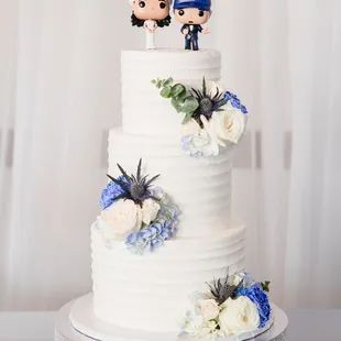 a wedding cake with figurines on top