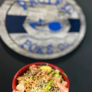 a bowl of sushi with salmon, avocado, and sesame seeds