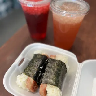 a plastic container with sushi and a drink