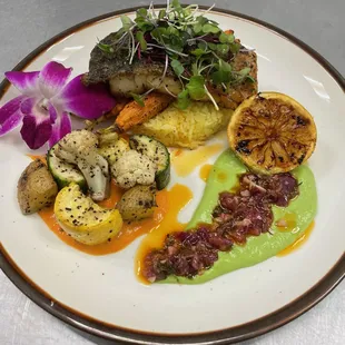 Grilled fish paired with saffron rice and grilled veggies. Side of roasted bell pepper and peas puree