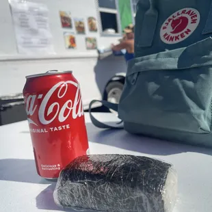 a can of soda and a bag of sushi