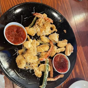 a plate of fried shrimp with dipping sauce