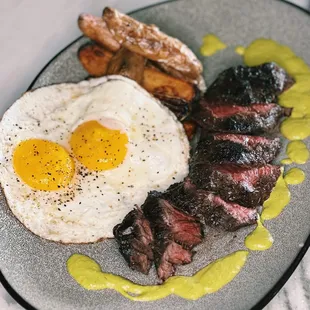 Steak &amp; Eggs with Wanderer Bavette 10 oz, 2 fried eggs, crispy potatoes, aji amarillo at Pacific Standard Prime steakhouse in Redondo Beach