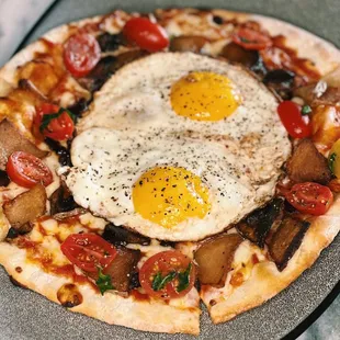 Breakfast Pizza with tomato, mozzarella, guanciale, potato, basil, 2 fried eggs at Pacific Standard Prime steakhouse in Redondo Beach
