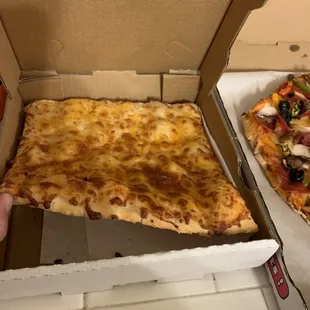 a hand holding a slice of pizza