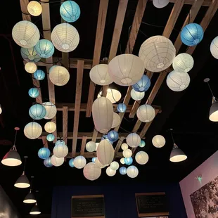 the ceiling of a restaurant with paper lanterns hanging from the ceiling