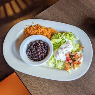 Accompaniment to the fajitas: rice, beans, guacamole, sour cream, lettuce and pico de gallo