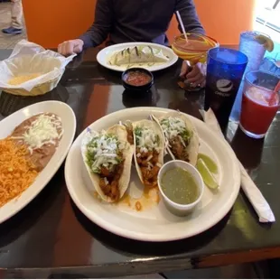 Street tacos serviced with rice and beans, burrito poblano with steak