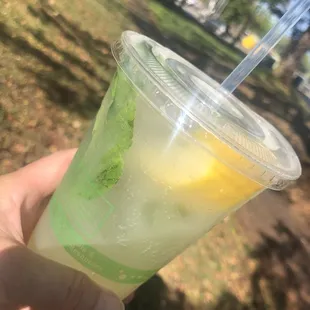 a hand holding a plastic cup with a drink in it