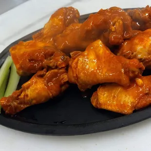 a plate of chicken wings and celery