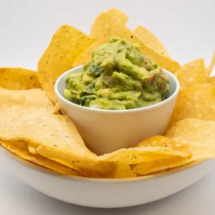  a bowl of guacamole and tortillas