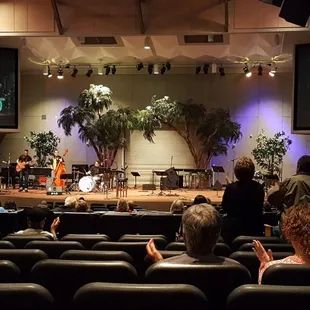a group of people sitting in front of a stage