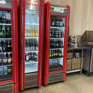 two refrigerators with drinks in them